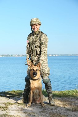 Alman çoban köpeği Nehri yakınında ile askeri üniformalı erkeklere