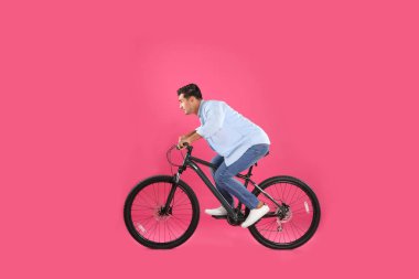 Pembe arka plan üzerinde modern bisiklet ile Yakışıklı genç adam