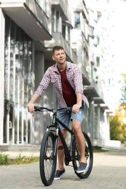 Şehir caddesinde modern bisiklet ile Yakışıklı adam