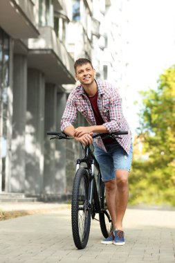 Şehir caddesinde modern bisiklet ile Yakışıklı adam