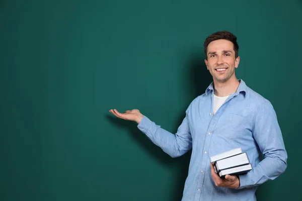 Portrait de professeur masculin avec des livres sur fond de couleur. Espace pour le texte — Photo