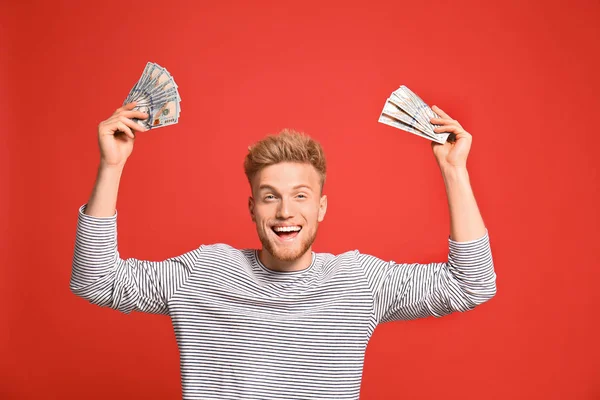 Portrait of happy lottery winner with money on red background — Stock Photo, Image
