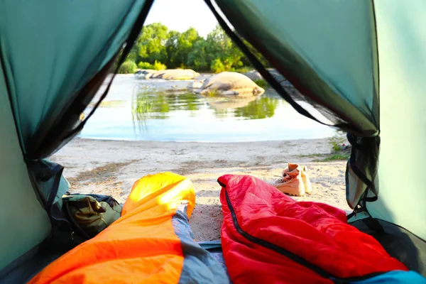 Zeltlager mit Schlafsäcken in der Nähe des Sees, Blick von innen — Stockfoto