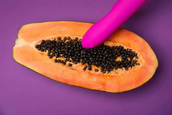 Mitad de papaya y vibrador sobre fondo morado, vista superior. Concepto de sexo — Foto de Stock