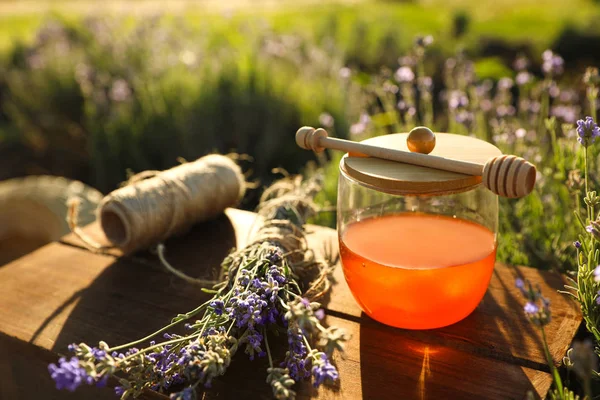 Sklenice medu na dřevěném stolku v levandulové oblasti — Stock fotografie