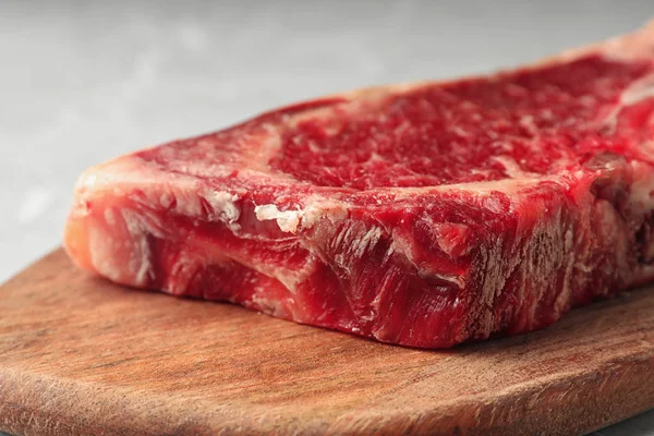 Сырое мясо говядины на деревянной доске, вид крупным планом — стоковое фото
