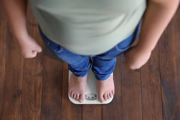Ragazzo in sovrappeso in piedi su scale a pavimento al chiuso, sopra la vista — Foto Stock