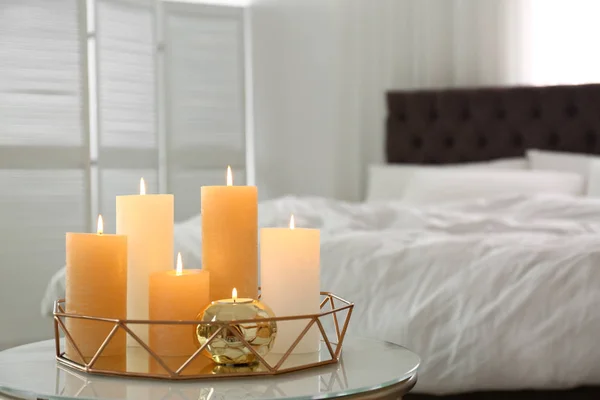 Złota taca z płonących świec na stole w sypialni — Zdjęcie stockowe