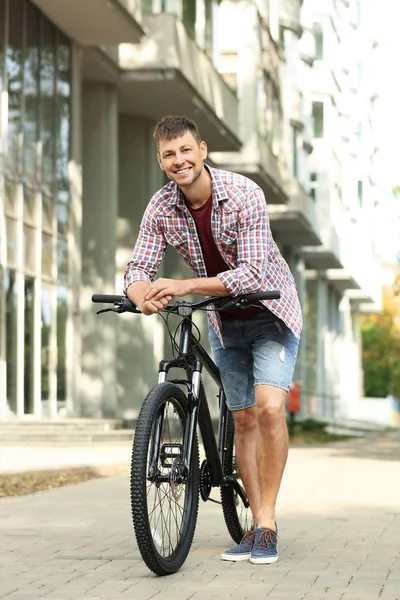 Pohledný muž s moderním bicyklu na městské ulici — Stock fotografie