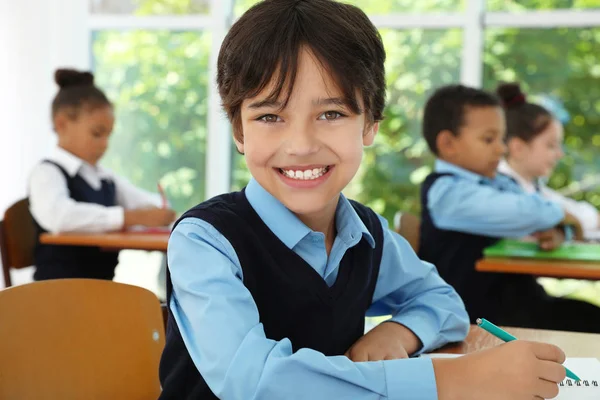 Jongen het dragen van nieuwe school uniform in het klaslokaal — Stockfoto