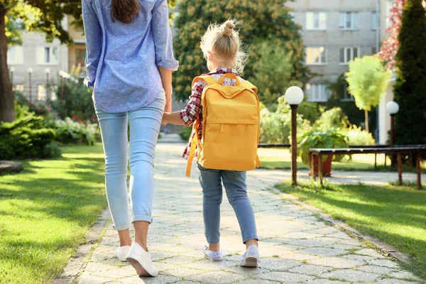 Jeune mère emmenant son petit enfant à l'école à travers le parc — Photo