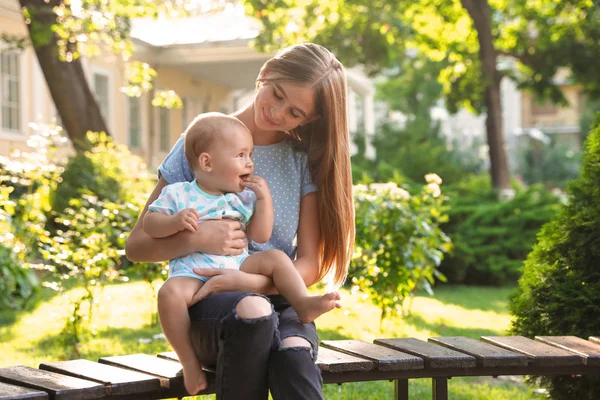 Teen Nanny med söt baby utomhus på solig dag — Stockfoto