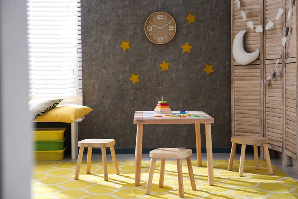 Интерьер детской комнаты с деревянной мебелью и игрушками — стоковое фото