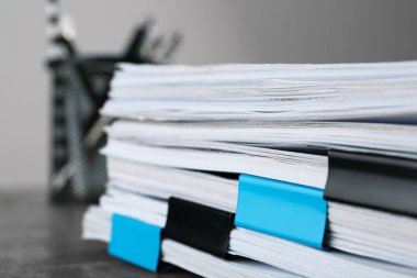 Gri taş tablo üzerinde klasör klipsleri olan belge yığını, yakın görünüm