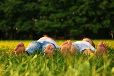 Mutlu çocuk parkta çim üzerinde yalan