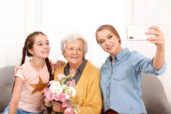 快乐的姐妹们自拍，他们的祖母在家里捧着鲜花 — 图库照片