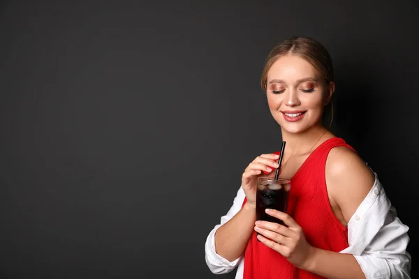 Giovane donna con bicchiere di cola su sfondo nero, spazio per testo. Bevanda rinfrescante — Foto Stock