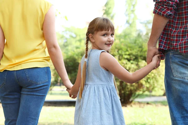 Niña y sus padres tomados de la mano al aire libre. Fin de semana familiar — Foto de Stock