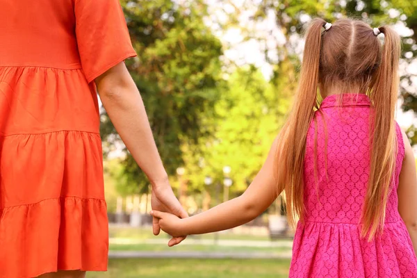 Little girl and her mother holding hands outdoors. Family weekend — Stock Photo, Image
