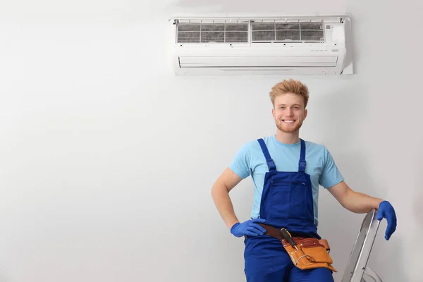 Technicien professionnel près de climatiseur moderne à l'intérieur — Photo