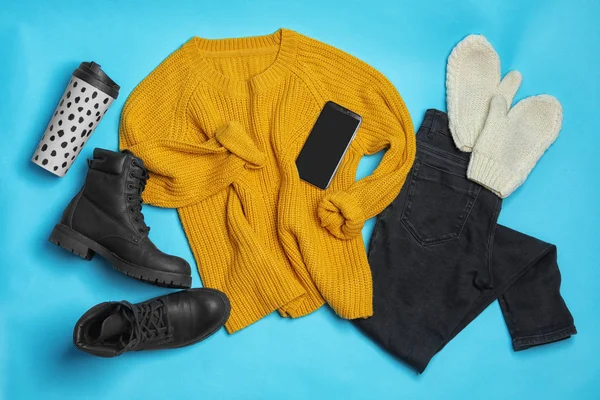 Composición plana con ropa de invierno y botas sobre fondo azul claro — Foto de Stock