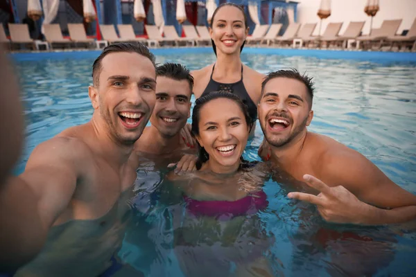 Felices jóvenes amigos tomando selfie en la piscina — Foto de Stock
