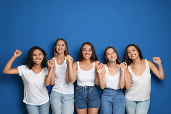 Ευτυχισμένες γυναίκες που κρατάνε τα χέρια τους σε μπλε φόντο. Ιδέα της δύναμης των κοριτσιών — Φωτογραφία Αρχείου