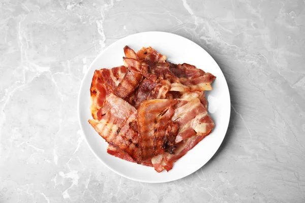 Fette di gustosa pancetta fritta sul tavolo di marmo chiaro, vista dall'alto — Foto Stock