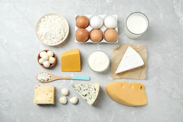 Diferentes productos lácteos en la mesa de mármol, plano — Foto de Stock