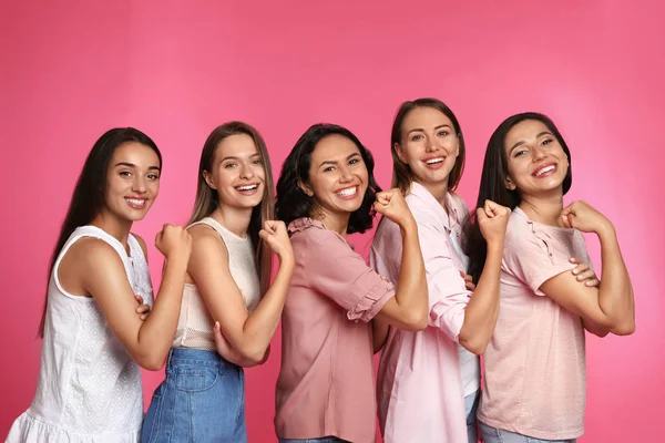 Lyckliga kvinnor poserar på rosa bakgrund. Girl Power Concept — Stockfoto