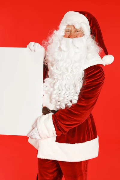 Authentischer Weihnachtsmann mit leerem Banner auf rotem Hintergrund. Raum für Gestaltung — Stockfoto