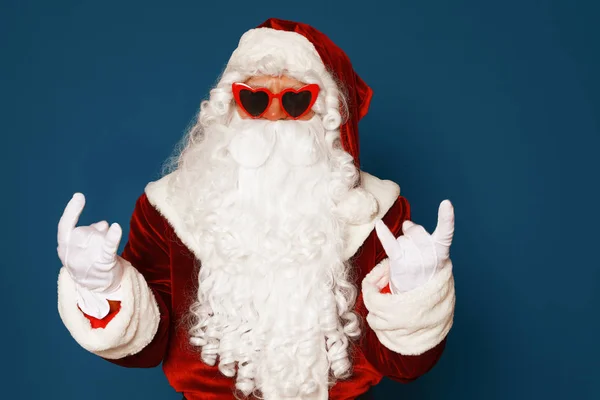 Autentyczny Święty Mikołaj noszenie okularów przeciwsłonecznych na niebieskim tle — Zdjęcie stockowe