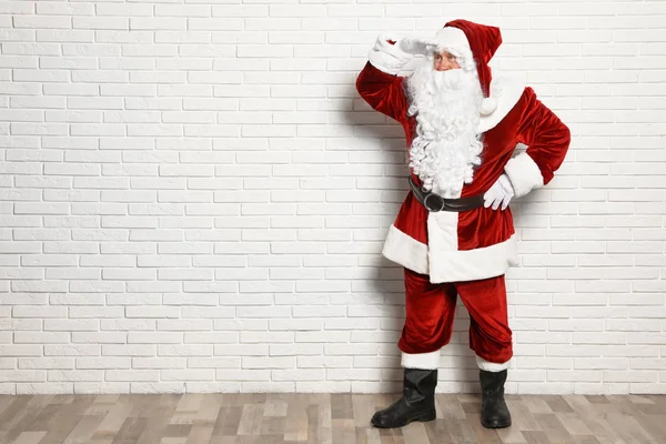 Auténtico Santa Claus contra la pared de ladrillo blanco. Espacio para texto —  Fotos de Stock