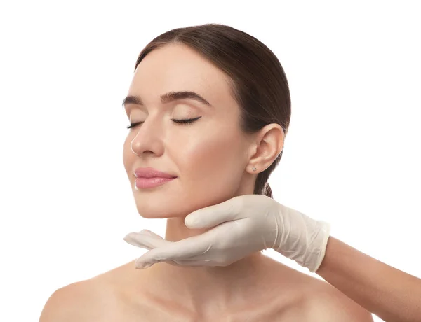 Dokter onderzoekt het gezicht van de vrouw voor plastische chirurgie op witte achtergrond — Stockfoto