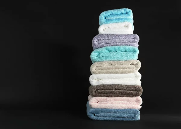 Verschiedene frische weiche Frottee-Handtücher auf dunklem Hintergrund. Raum für Text — Stockfoto