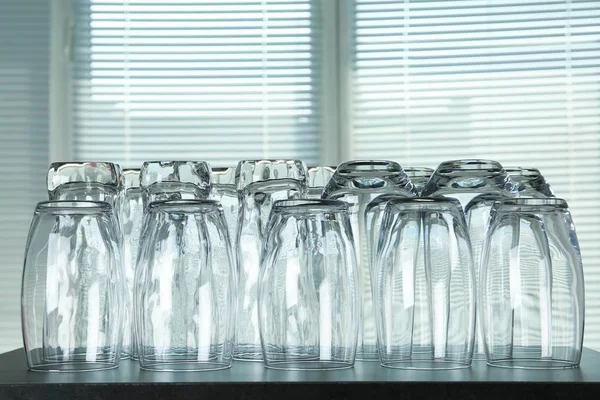Empty glasses on grey table against blurred background — Stock Photo, Image