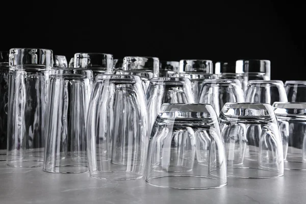 Empty glasses on marble table against black background — Stock Photo, Image