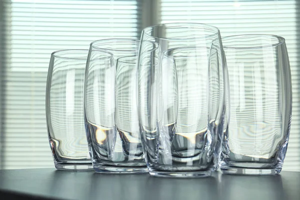 Empty glasses on grey table against blurred background, closeup — Stock Photo, Image