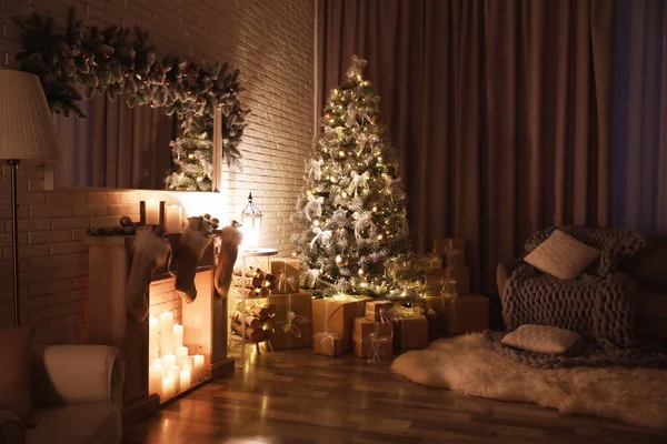 Stijlvol interieur met mooie kerstboom en kunstmatige open haard 's nachts — Stockfoto