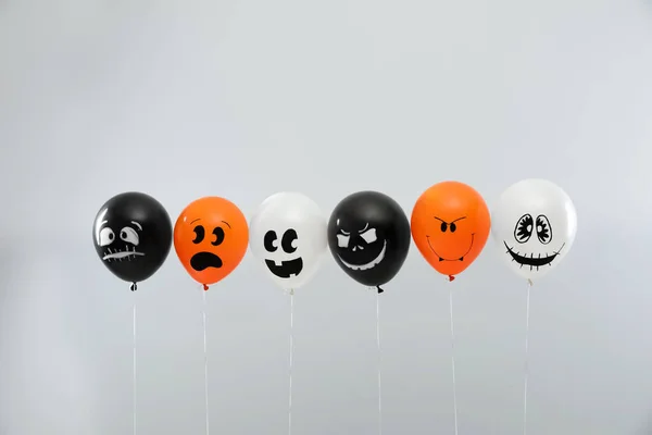 Ballons fantomatiques pour la fête d'Halloween sur fond gris clair — Photo