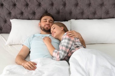 Genç çift evde yatakta yatmaya