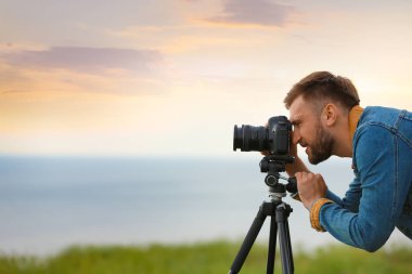 Erkek fotoğrafçı profesyonel kamera açık havada güzel manzara fotoğraf çekmek. Metin için alan