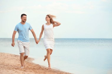 Mutlu romantik çift plajda birlikte çalışan, metin için alan