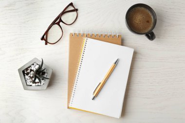 Beyaz ahşap masa üzerinde ofis kırtasiye ve kahve fincan ile Düz yatıyordu kompozisyon