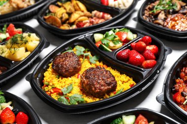 Beslenme çantalarında beyaz masada farklı yemekler var. Sağlıklı yemek servisi.