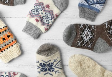 Beyaz ahşap arka plan üzerinde farklı örme çorap, düz yatıyordu