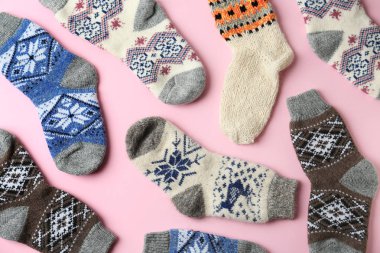 Pembe arka planda farklı örülmüş çoraplar, düz yatış. Kış giysileri