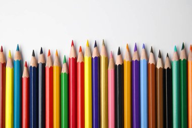 Beyaz arkaplanda renkli kalemlerle kompozisyon, üst görünüm