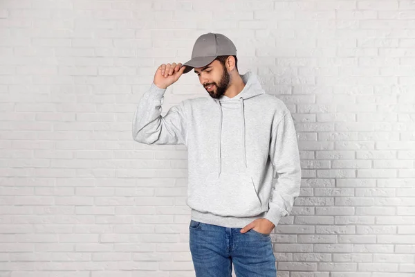 Porträt eines jungen Mannes im Pullover an der Ziegelwand. Mock up für Design — Stockfoto