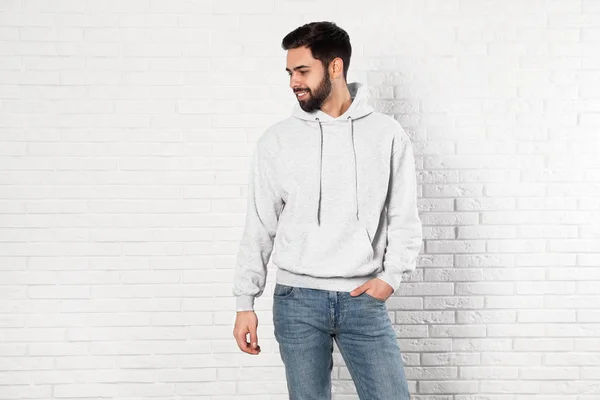 Porträt eines jungen Mannes im Pullover an der Ziegelwand. Mock up für Design — Stockfoto